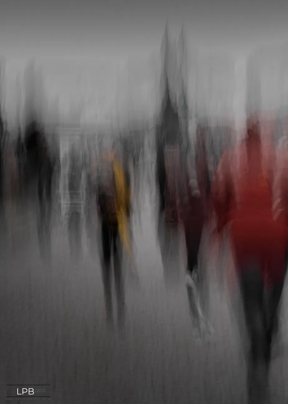 Pedestrians dissolved into vertical streaks, a red coat and yellow umbrella the only colour